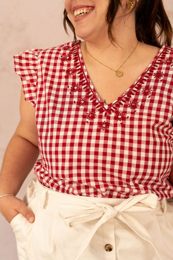 Détail de la broderie fleurie sur la blouse à carreaux Vichy grande taille