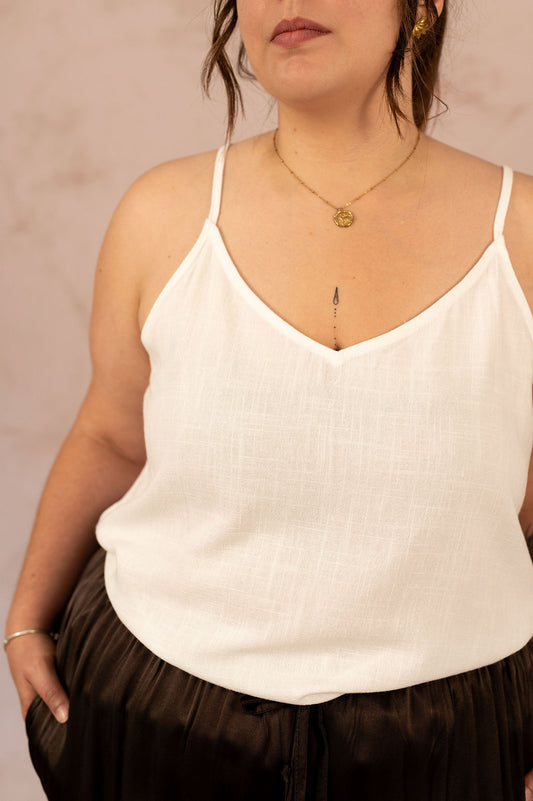 Zoom sur le col en V d’un top blanc grande taille à bretelles