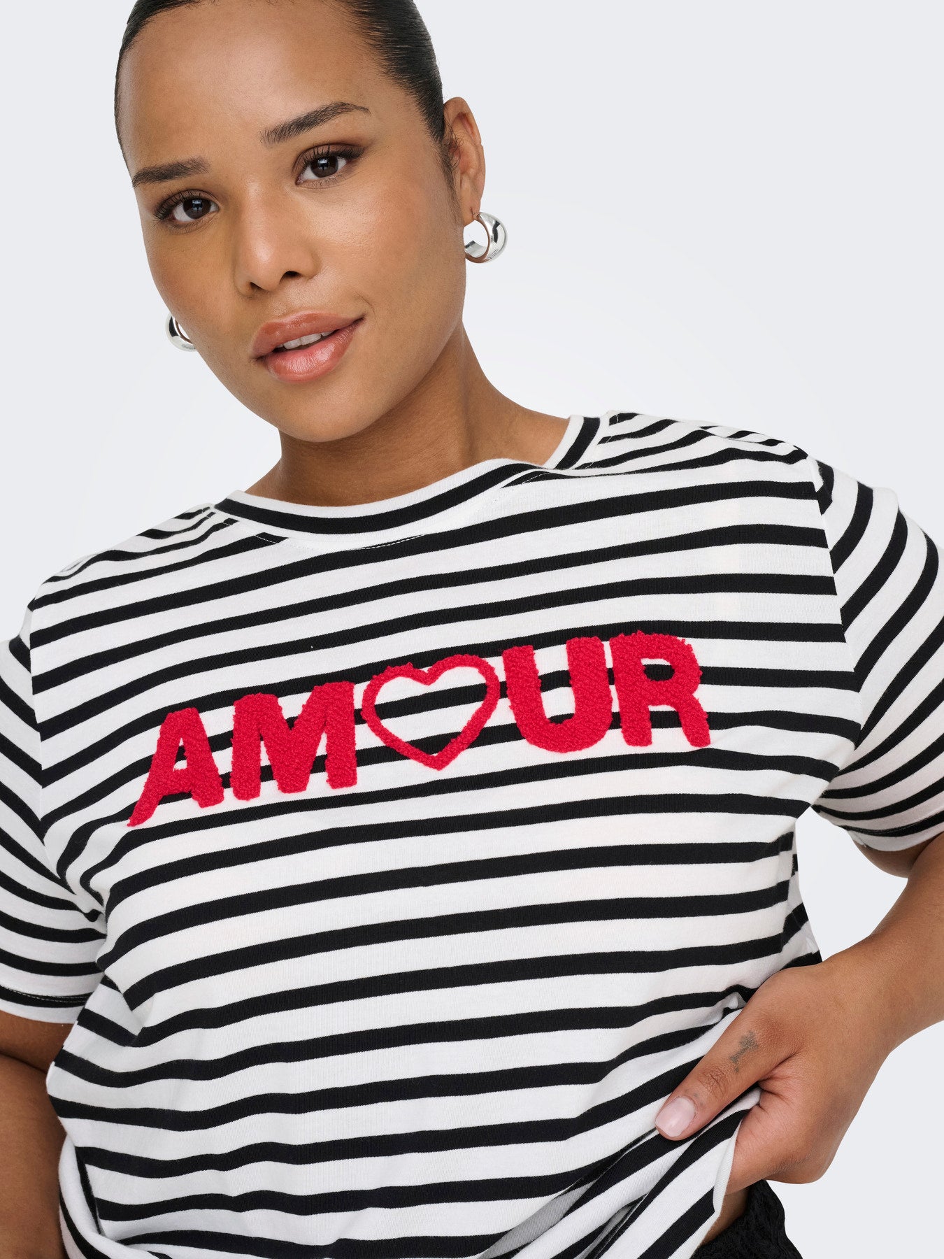 Femme portant un t-shirt marinière grande taille avec broderie rouge AMOUR