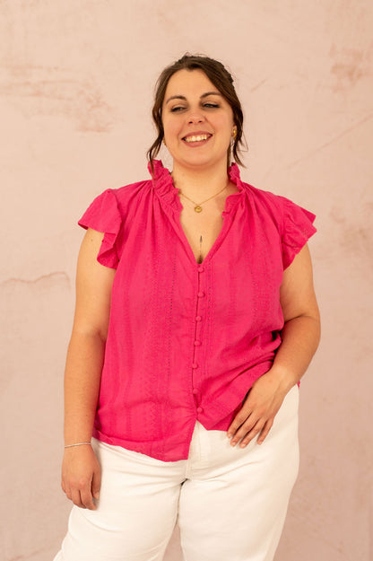 Portrait de femme souriante en blouse Alizée avec col volanté et broderie anglaise.