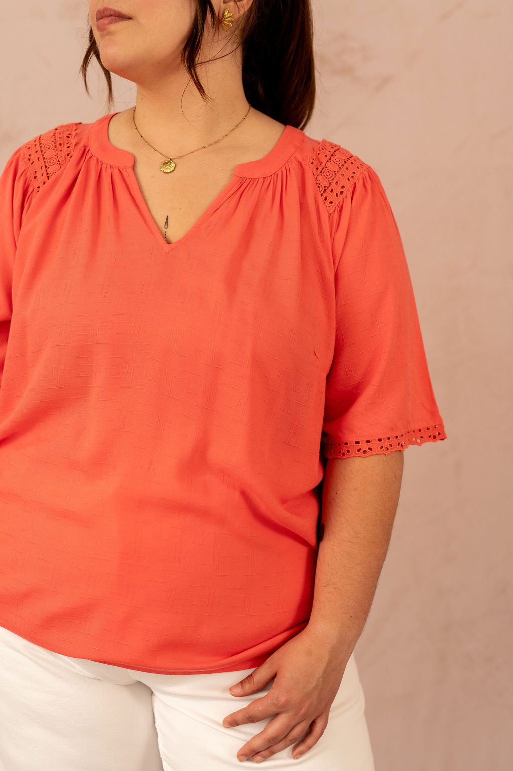 Détail du col en V et des broderies sur les épaules de la blouse grande taille