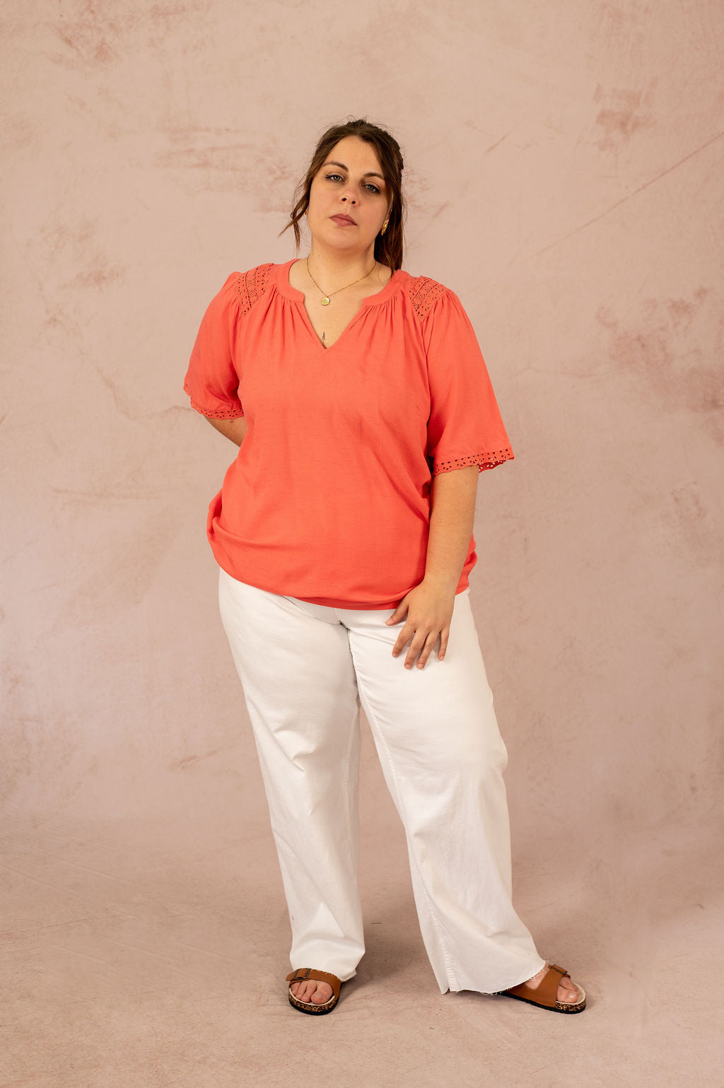 Femme portant une blouse corail avec empiècements en broderie anglaise, vue de face – mode grande taille