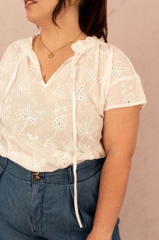 Gros plan sur la blouse Camilla avec broderie anglaise et col volanté avec lien à nouer.