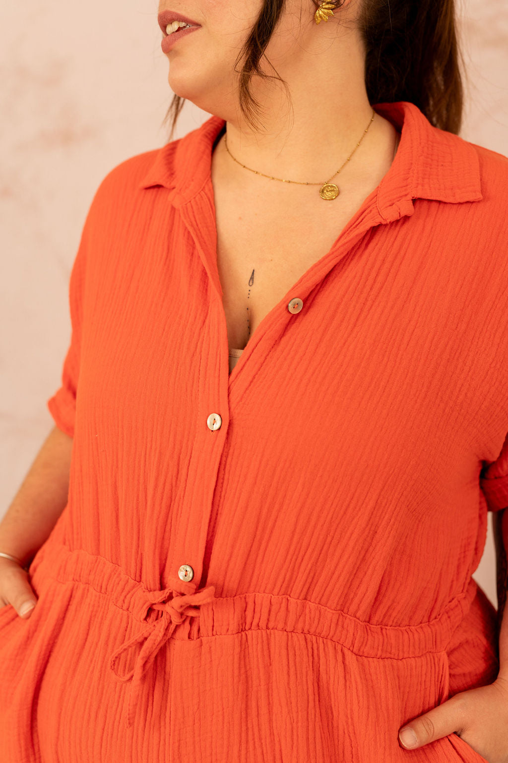 Détail des boutons et du col sur un combishort orange en gaze de coton