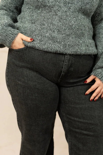 Jean noir coupe large porté par un mannequin plus size – détail

