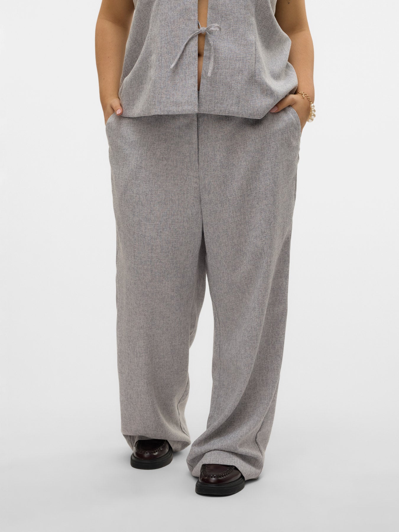 Zoom sur le pantalon Tammi droit de tailleur gris porté de face, détails de la coupe et des poches