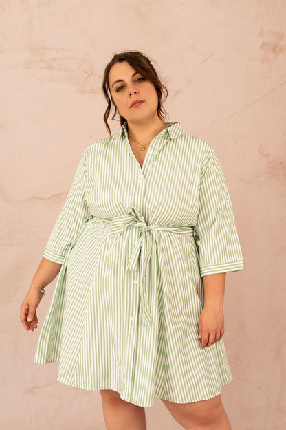 Femme souriante portant une robe chemise rayée verte avec ceinture
