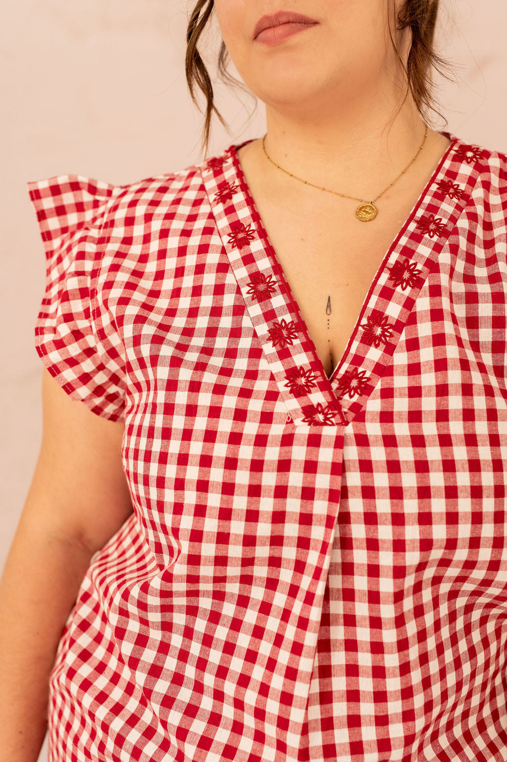 Détail de la broderie fleurie sur la robe Vichy grande taille