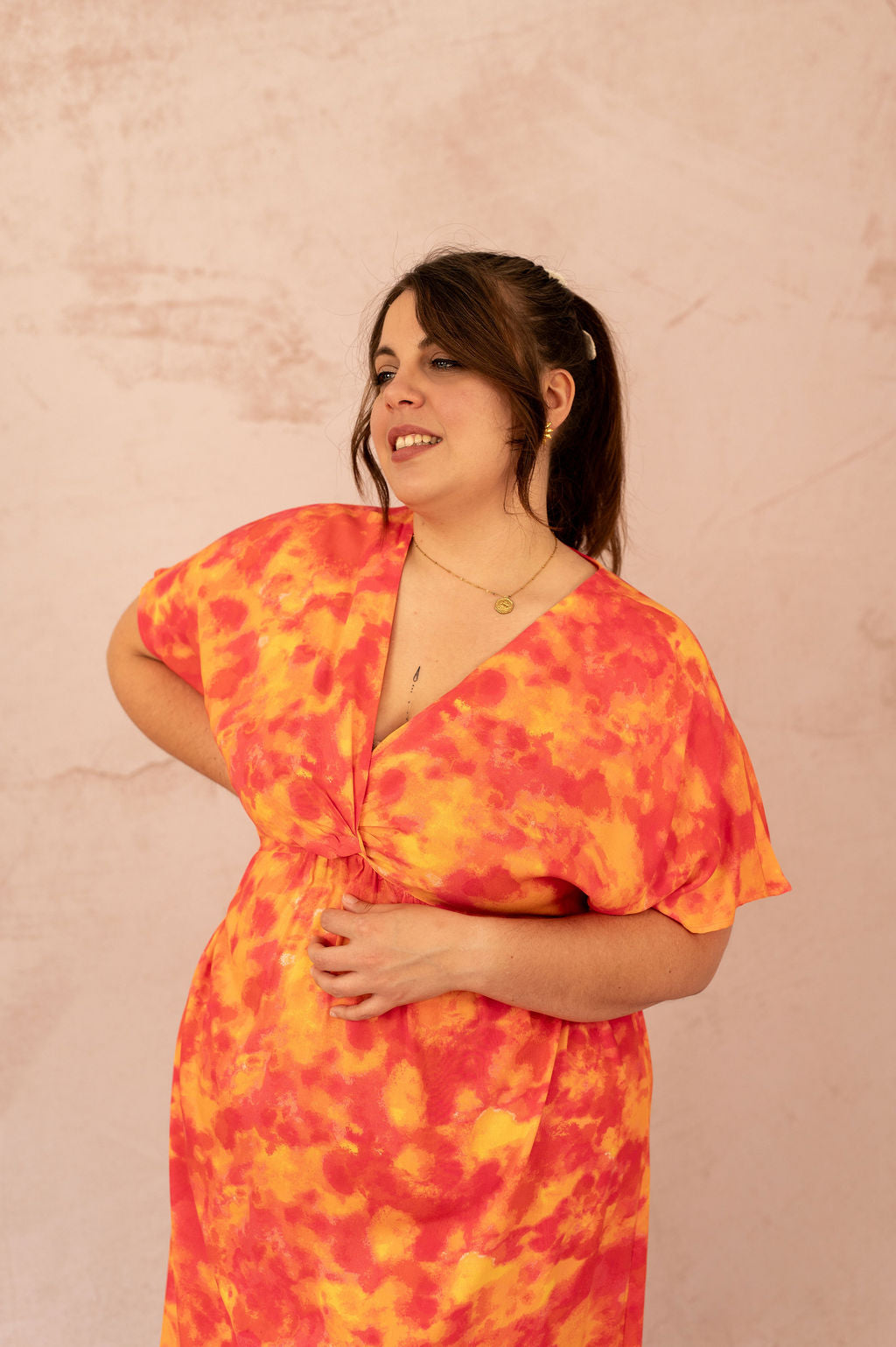 Zoom sur le décolleté croisé de la robe Ciana imprimée orange et rose