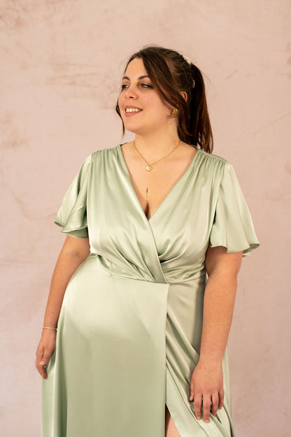 Zoom sur le décolleté croisé et les manches courtes fluides de la robe Luisa en satin vert – Robe cérémonie grande taille