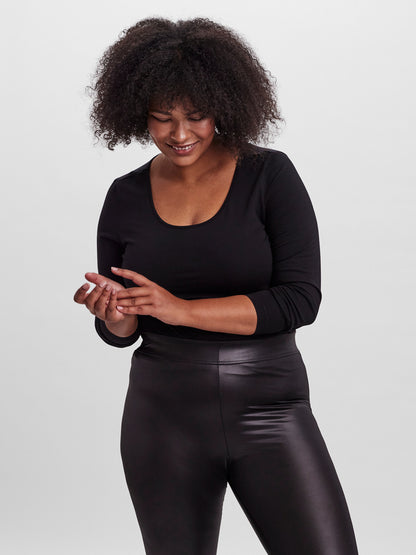 Femme souriante portant un t-shirt noir à manches longues grande taille