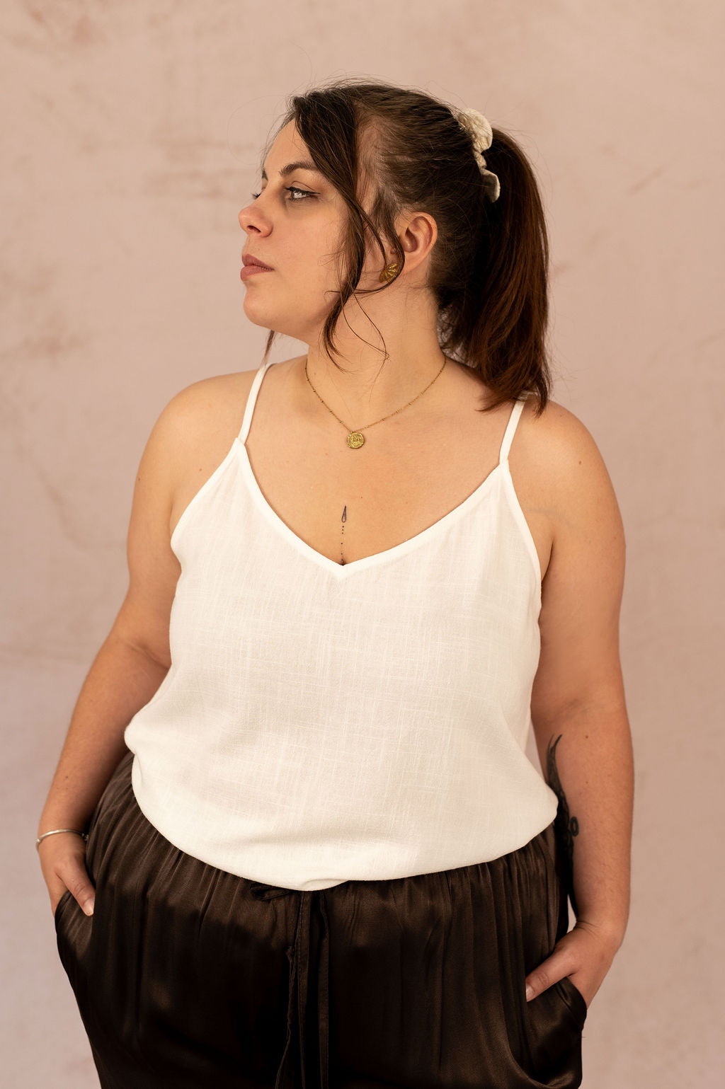 Femme grande taille portant un top blanc fluide avec col V et bretelles fines