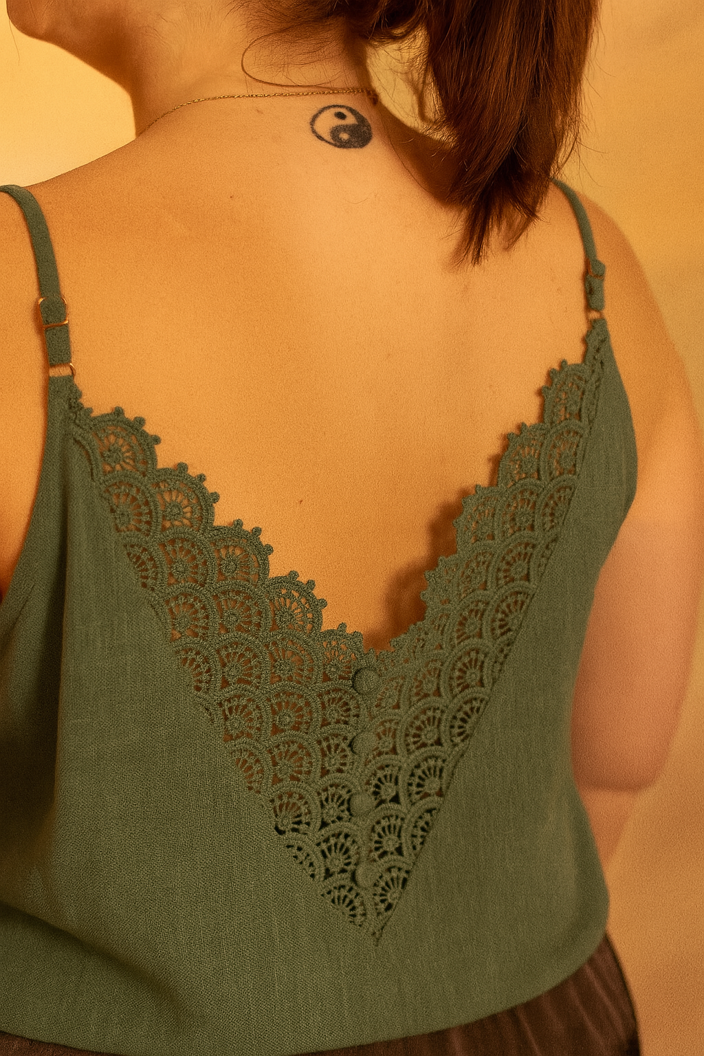 Femme grande taille portant un top kaki avec dentelle dans le dos