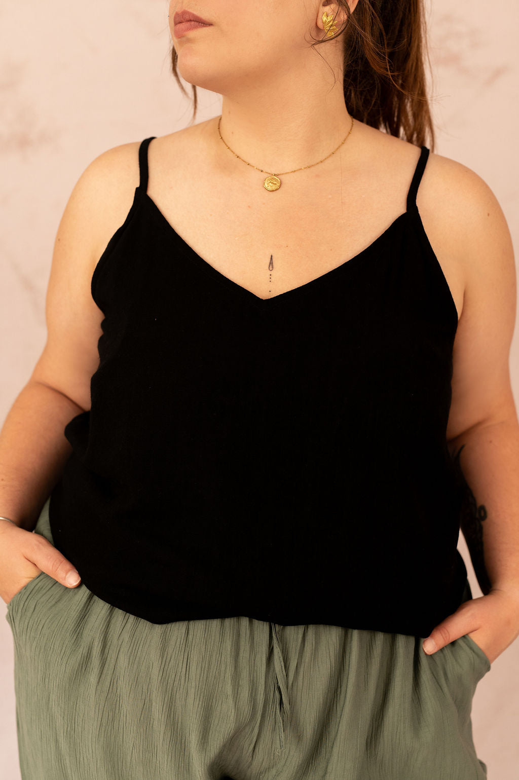 Détail du col en V d’un top noir fluide grande taille avec bretelles fines