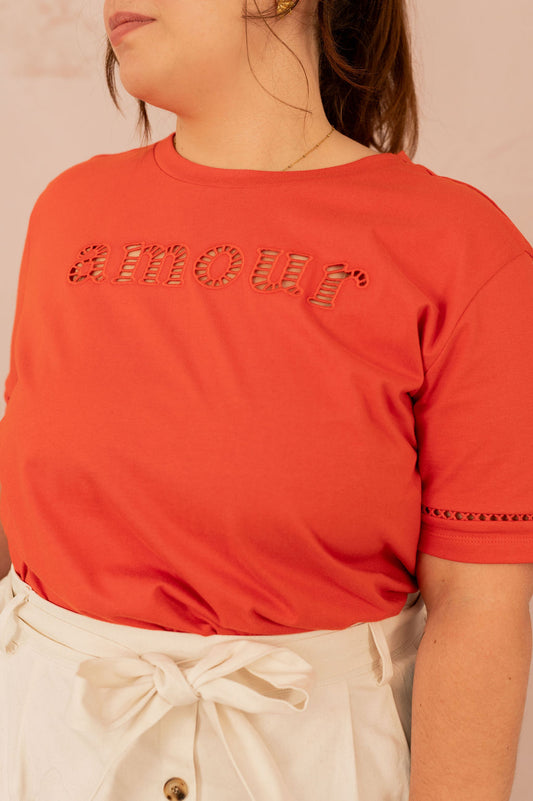 Femme portant un t-shirt rouge avec l’inscription "amour", vue de face