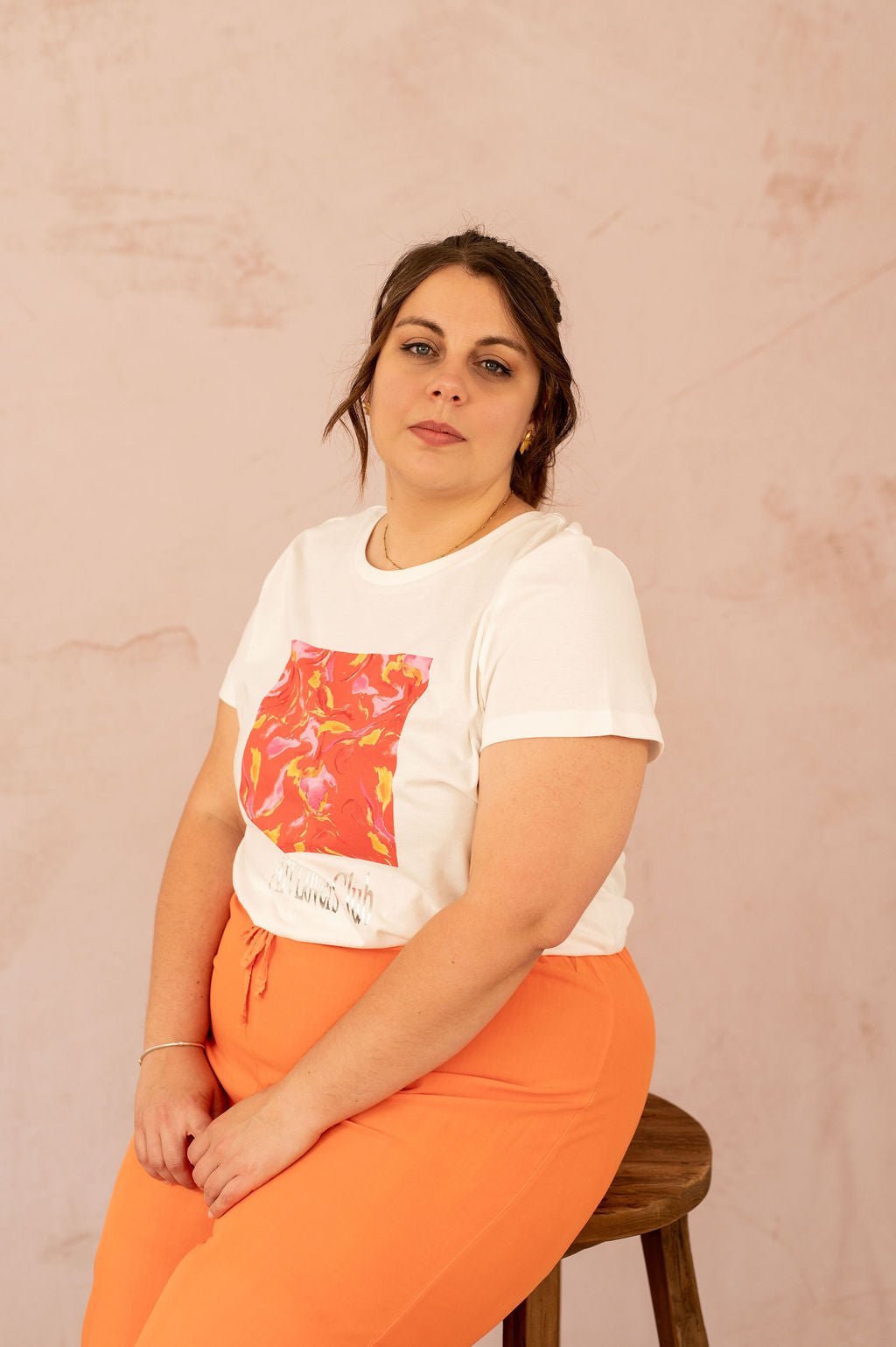 Femme assise portant un t-shirt imprimé blanc grande taille, style décontracté