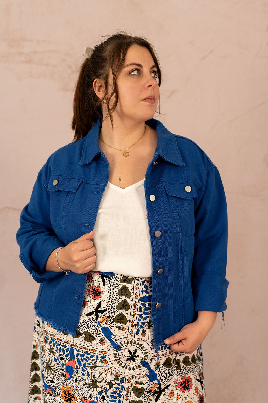 Veste en jean bleu électrique portée ouverte sur un top blanc par une femme grande taille