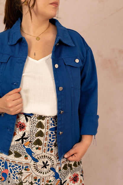 Détail des boutons pression argentés sur une veste en jean bleu portée par une femme grande taille