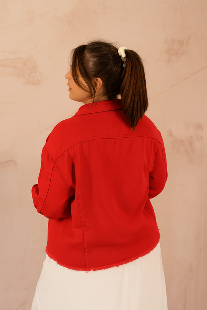 Dos de la veste en jean rouge avec finition frangée sur le bas